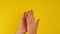 Two male hands clapping on a yellow background