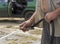 Two male hands holding a hose with water spurting out