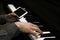 Two male hands on the piano with a smartphone. palms lie on the keys and play the keyboard instrument in a music school. student