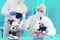 Two Male Scientists in PPE Suit working in Lab while Checking Result of Blood Sample testing.