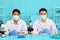 Two Male Scientists wear Face Mask working in Lab while Looking at Camera and Ready to Work and Presentation.