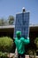 Two male solar workers install solar panels