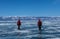 Two male tourists walk on frozen Baikal lake,Russia