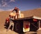 Two male workers unload bags of cement