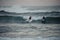 Two man and woman surfers caught a small wave on surf boards