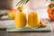 Two mango lassi or kesar milk in glasses. Indian healthy ayurvedic cold drink with mango. Freshness lassi made of yogurt, water,