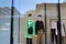 Two mannequins in a store window with one wearing a green shirt and the other wearing a black pullover sweater with a zipper