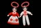 two martenitsa dolls in red and white clothing with red ribbons