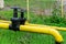 Two massive black valves on a yellow gas pipe