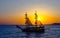 Two-masted sailing ship on the background of the setting sun.