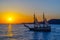 Two-masted sailing ship on the background of the setting sun.