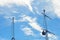 Two masts of a yacht with rigging seen against a blue sky with white clouds.