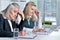 Two mature businesswomen sitting at table with laptop and working together