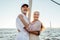 Two mature people standing at mast on sailboat