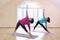 Two mature women doing yoga exercise in fitness studio