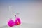 Two medical flasks with pink chemical reagent and testing kit isolated on white. Laboratory research of Coronavirus