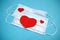 Two medical mask and red hearts symbols, valentine`s day in pandemic time concept