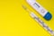 Two medical thermometer-mercury and electronic, are on uniform yellow background with clean empty area for labels or headers top