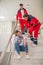 Two medical workers in red uniform coming to a woman on the stairs