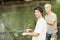 Two men angling beside river