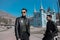 Two men in black clothing style are standing in the city of Pyatigorsk, Stavropol Territory, in a park, a flower garden posing for