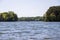 Two men on a boat fishing surrounded by the rippling blue water of Lake Lanier and lush green trees and plants