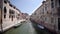 Two men in a boat sail in canal. Venice Italy