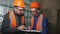 Two men of the builders in the protective helmets in the room to discuss a plan of construction works.