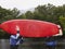 Two men carrying kayak outdoors