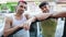 Two men couple smiling confident leaning on door car at street