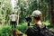 Two men create video content on a hike with a camera on the stabilizer  the guy shoots a friend standing on a stump in the