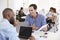 Two men discussing business documents in a busy office