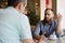 Two men discussing difficult issues with emotions during coffee break in cafe talking about problems of business negotiation