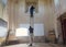 Two men facility service workers fixing old chapel interior from stepladder