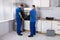 Two Men Fixing Oven In Kitchen