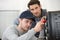 two men fixing oven in kitchen