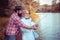 Two men friends fishing. Flyfishing angler makes cast, standing in river water. Old and young fisherman.