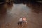 Two men friends fishing. Flyfishing angler makes cast, standing in river water. Old and young fisherman.