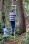 Two men hold ladder and climb safely in forest