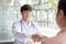 Two men holding hands, Asian doctor smiled shake hands with the patient congratulating him on being healthy and strong, Successful