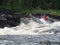 Two men on an inflatable catamaran overcome the threshold on the river