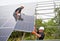 Two men installing solar panel system outdoors.