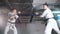 Two men in kimono training kendo on a parking lot. Sword fight