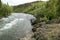 Two men launching canoe on wild Alaskan river