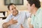 Two men in living room talking and smiling