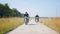 Two men motorcyclists riding motorbikes on the rye field - dusty road