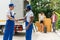 Two men movers worker in blue uniform making handshake to work success moving to new house. Homeowner couple checking delivery