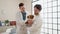 Two men petting dog shake hands at veterinary clinic