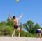 Two men play beach volleyball
