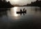 two men rowing through the dusk.. looking for fish